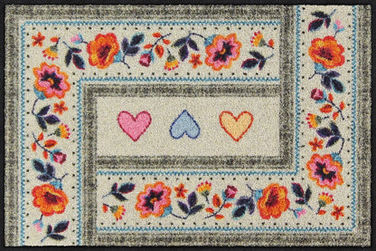 Salonloewe Fußmatte mit drei Herzen und floralem Boho-Muster auf beigem Hintergrund